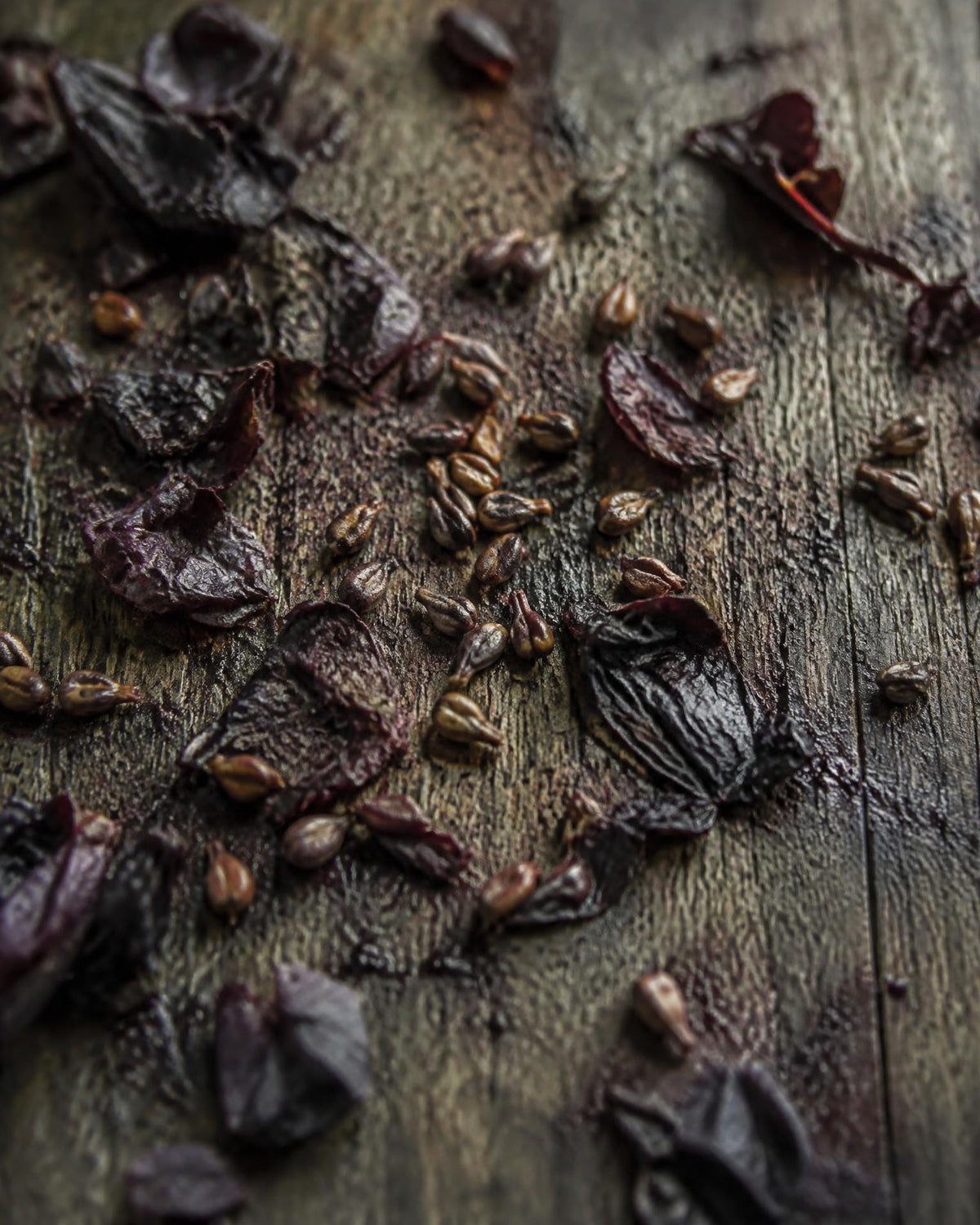 Grape seeds and pressed grape skins scattered on an old oak board
